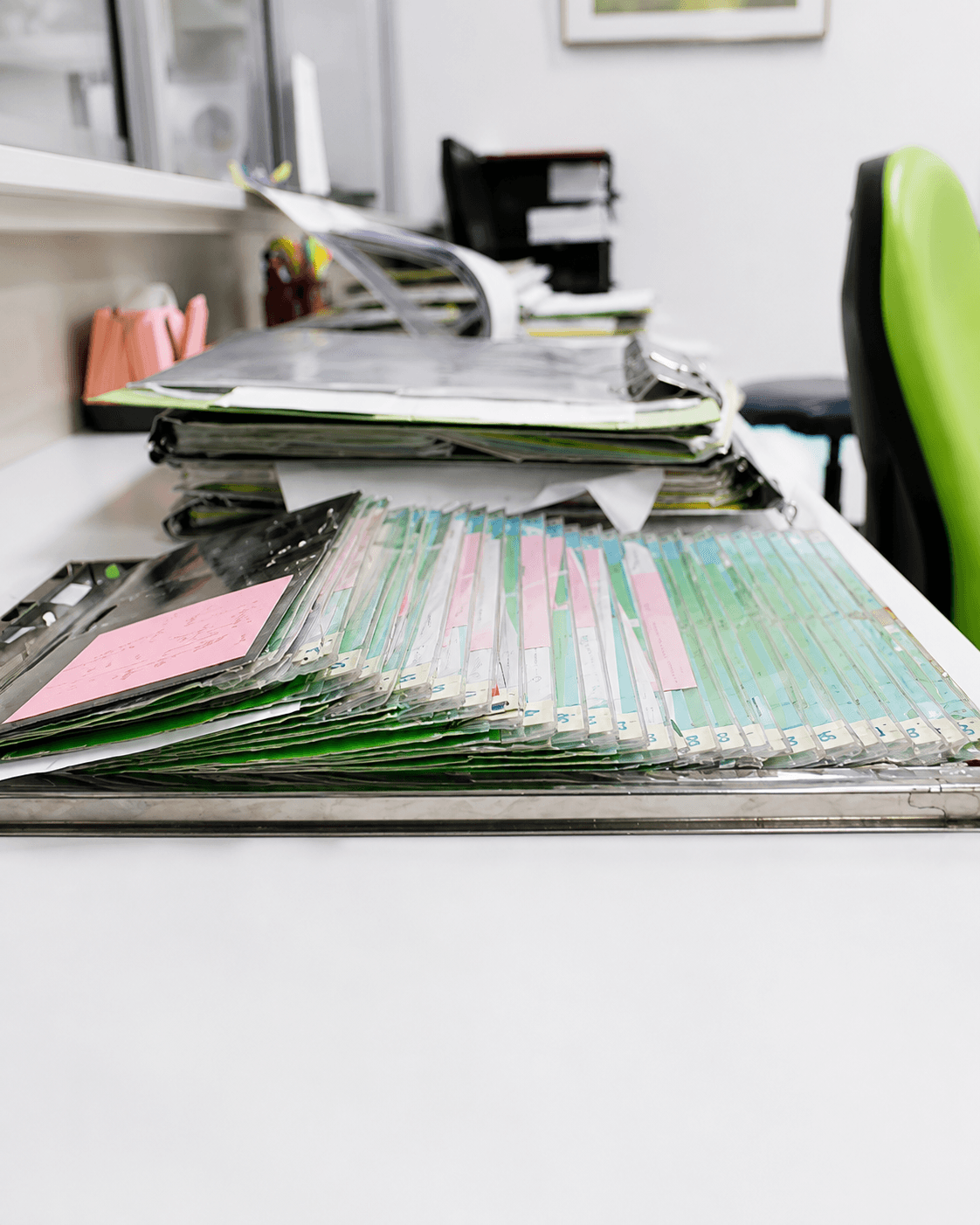 Rack of tabbed job cards in a metal tray on an office desk
